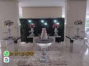 Decoração de festa de 15 anos com mesa espelhada retangular, mesas quadradas, mesa de pedraria, jarros cinza, castiçais e painel muro inglês — ideal para casamentos e debutantes no RJ